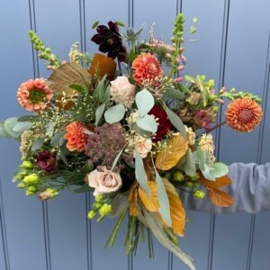 Autumn style bouquet in orange, brown and green tones.