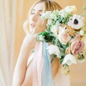 Beautiful bride with bouquet of flowers and trailing personalised ribbons