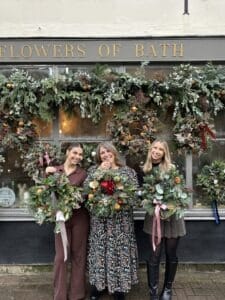 Three ladies outside Flowers of Bath holding their wreaths