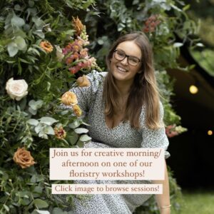 Ella nestled amongst floral display outdoors