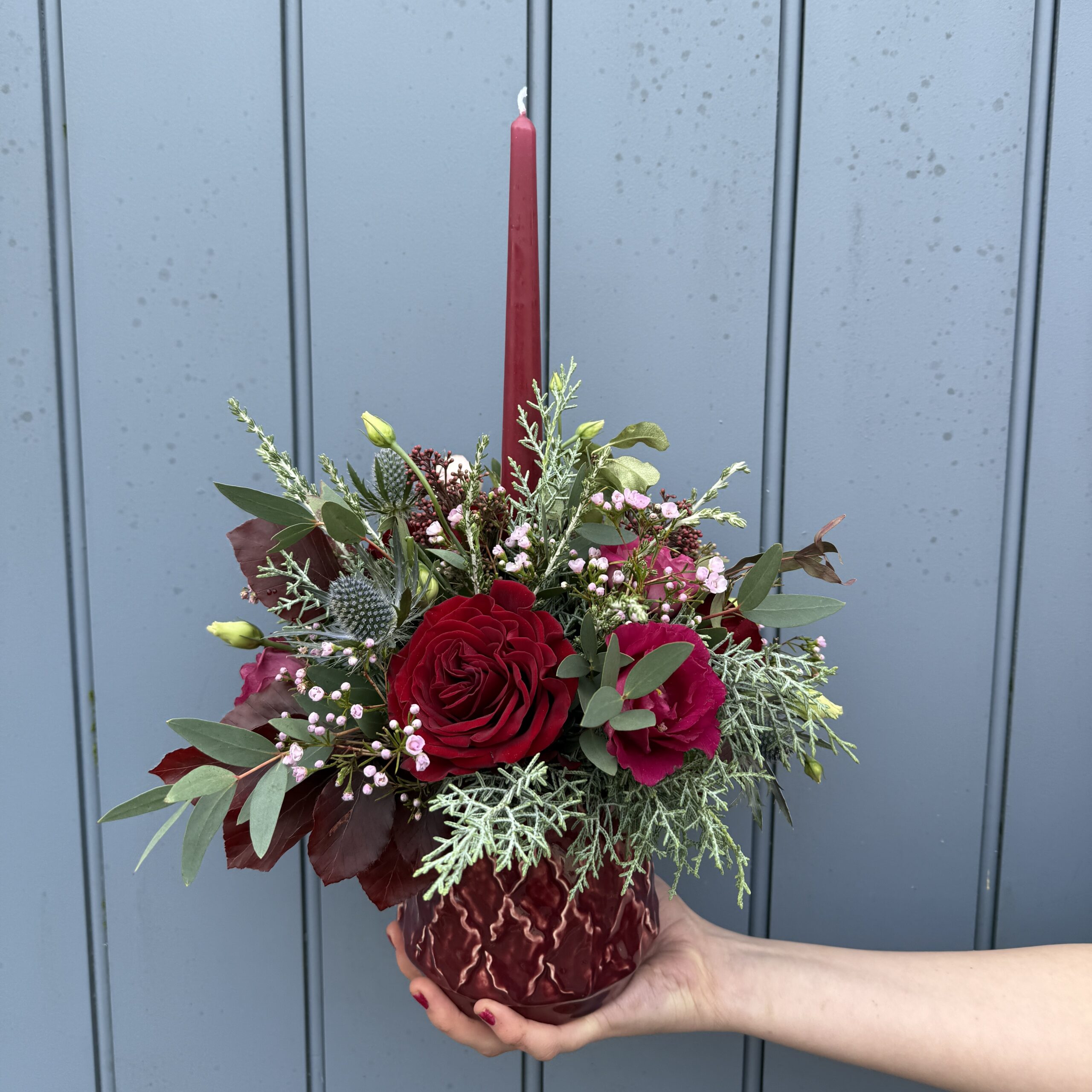 Festive table display in burgundy and red tones with a candle