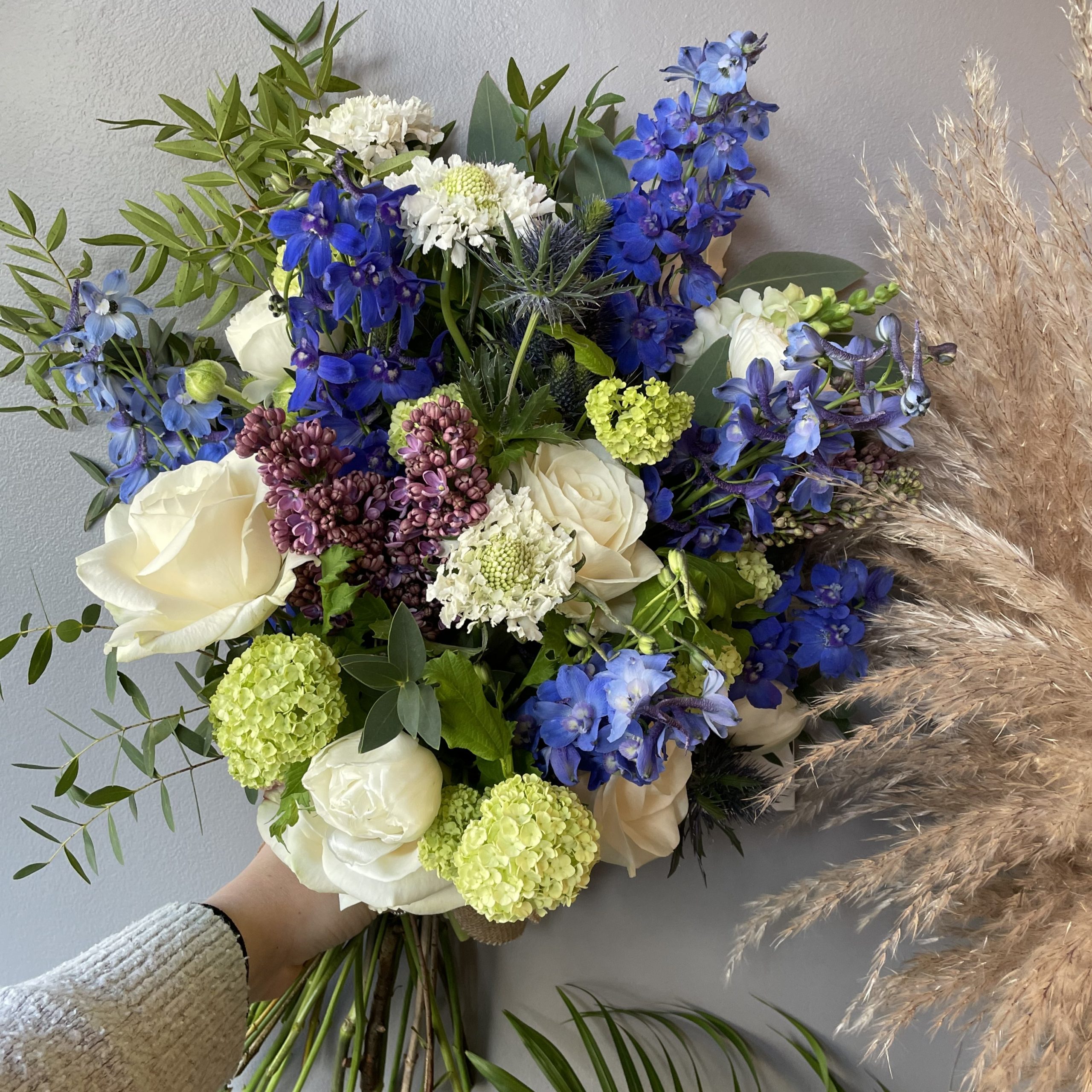 Blue, cream and lime tied sheaf funeral arrangement