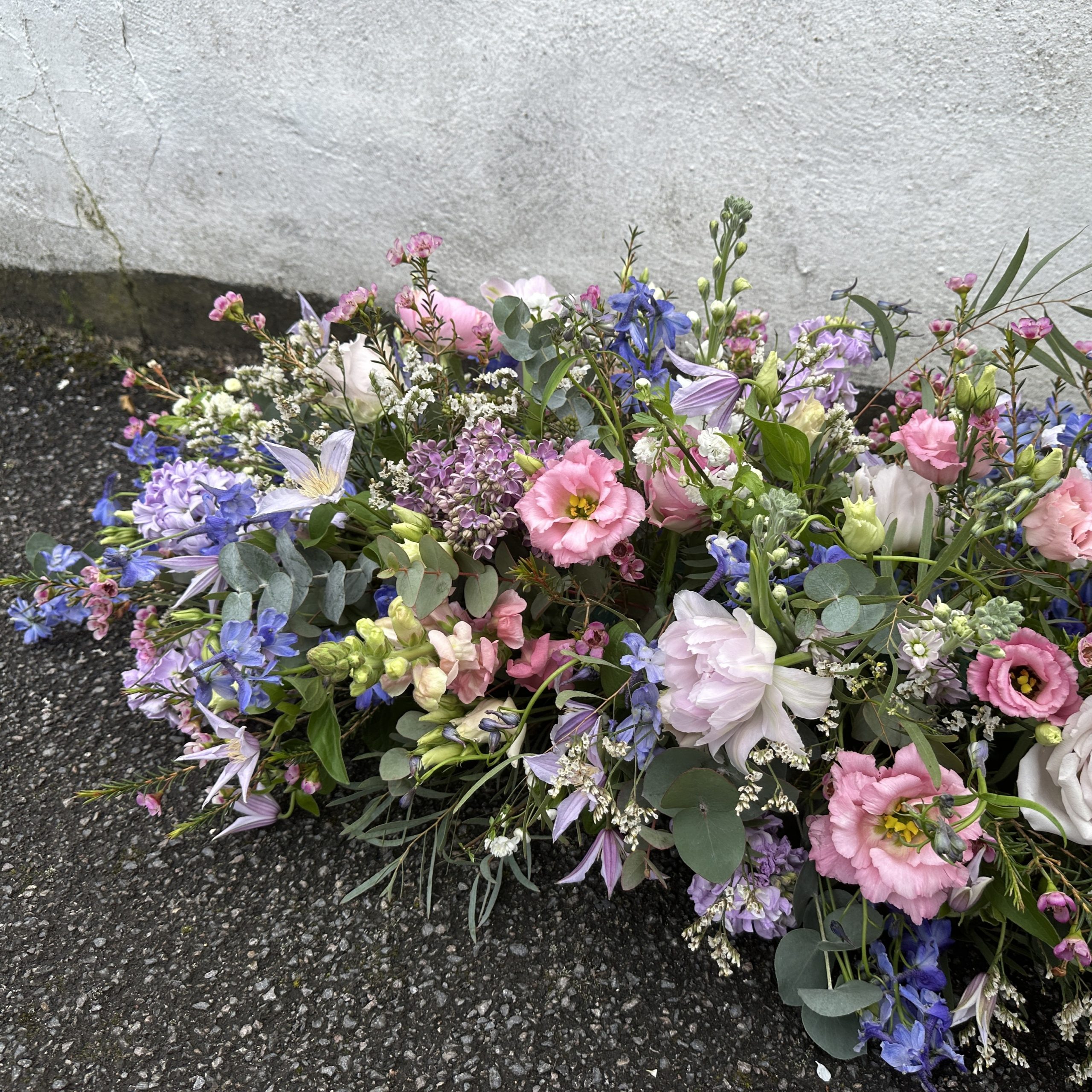 Double ended coffin arrangement in pastel pinks and blue